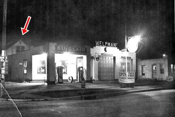 1950s photo with a night view of a Sinclair gas station in black and white